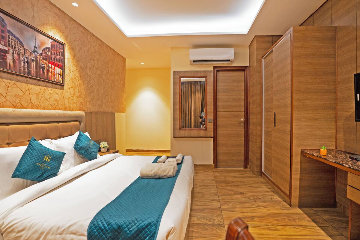 Una habitación de hotel con una cama, un escritorio y un armario.