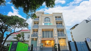 A hotel with a prominent sign, multiple balconies, and a tiled entrance area. - The Riverstone Inn - Near India Expo Centre & Mart, Greater Noida (Greater Noida)