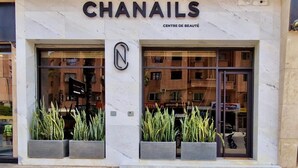 Das Gebäude von CHANAILS mit großen Fenstern und einer Marmorfassade.
