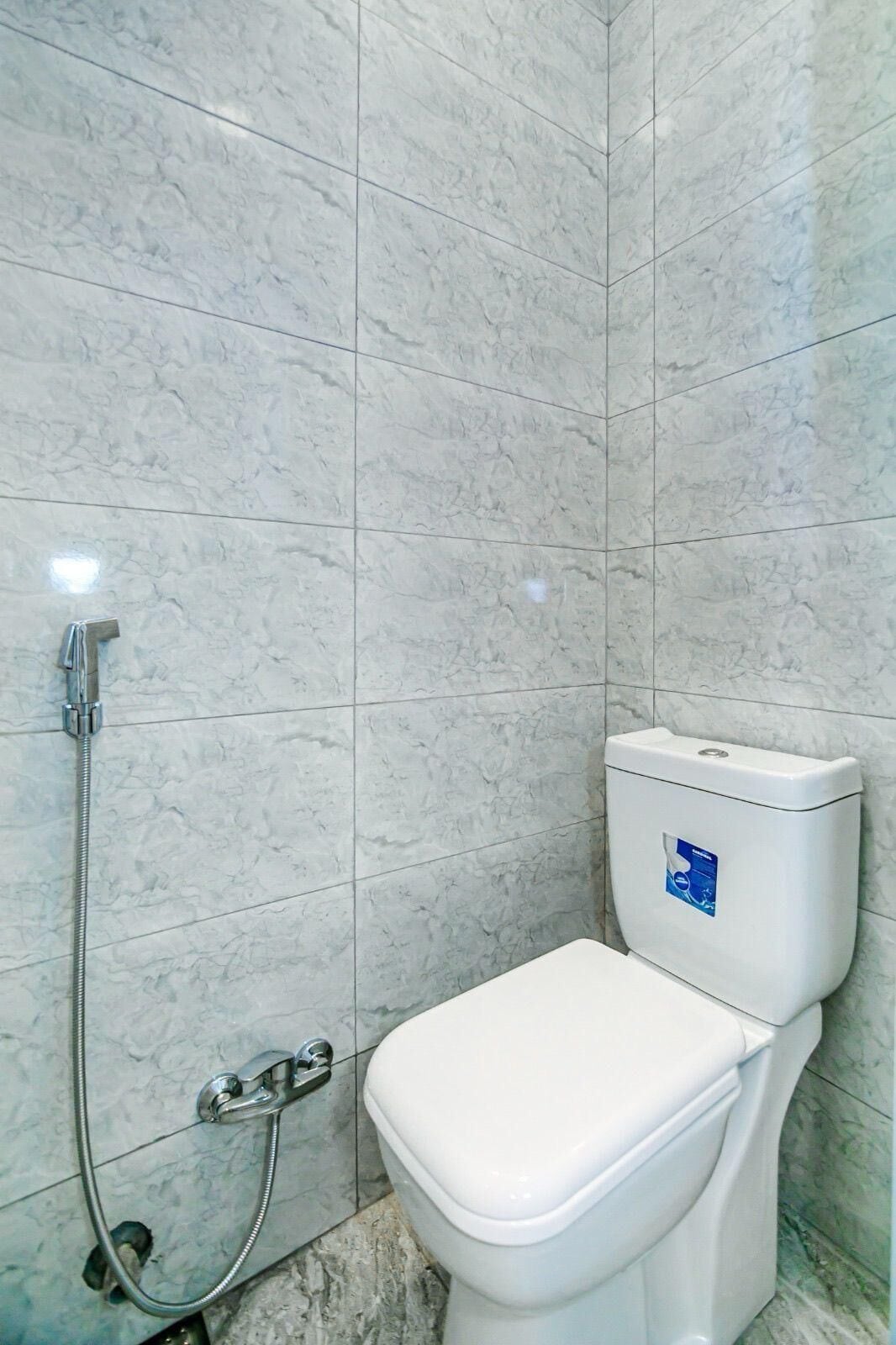 A bathroom with a toilet and a shower.