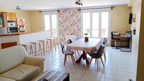 Un saló modern amb un sofà, una taula de centre i una zona de dinar amb una taula i caires.