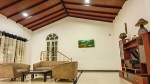 A spacious living room with a high ceiling, a staircase, and a painting on the wall. - 4-bedroom villa in wonderful Kadahapola with WiFi, AC, fitness room (Kadahapola ,Narammala)
