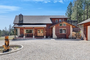 A log cabin with a stone foundation, a porch with seating, and a stone fireplace. - Cozy Mountain Cabin Close to Town (Darby)