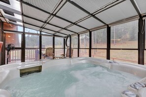 Un espace avec un bain à remous offrant une vue sur une forêt.