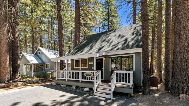 A lodge with a porch, wooden steps, and a signboard.