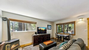 A cozy living room with a fireplace, a television, and a dining area.