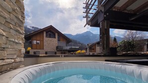 Un jacuzzi con vistas despejadas a una cordillera en el fondo.