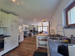 A modern kitchen with white cabinets, a wooden countertop, and a built-in oven.