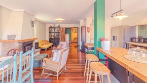A spacious living area with a fireplace, seating, and a kitchen area with a bar.