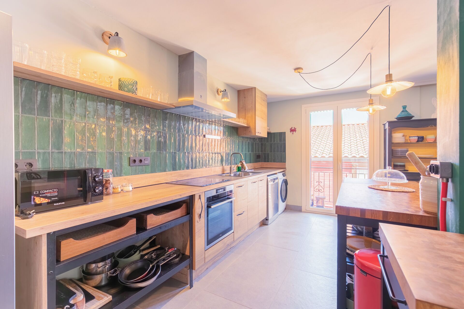 Een moderne keuken met houten kastjes, een magnetron, een spoelbak en een vaatwasser.