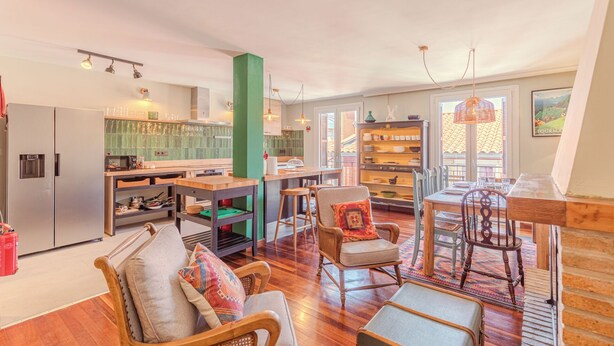 A spacious living area with a kitchen, dining area, and a large window with a view.