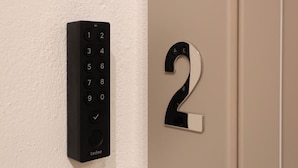 Un clavier à code fixé au mur et un numéro de porte.