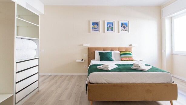 Une chambre à coucher avec un lit, une armoire et une fenêtre.