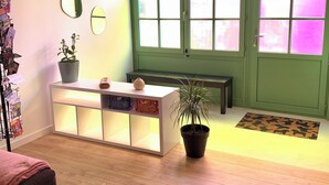 A room with a wooden floor, a white reception desk, a green door, and a potted plant. - Large duplex in the heart of the village of Carnac, near historic sites & beaches (Carnac)