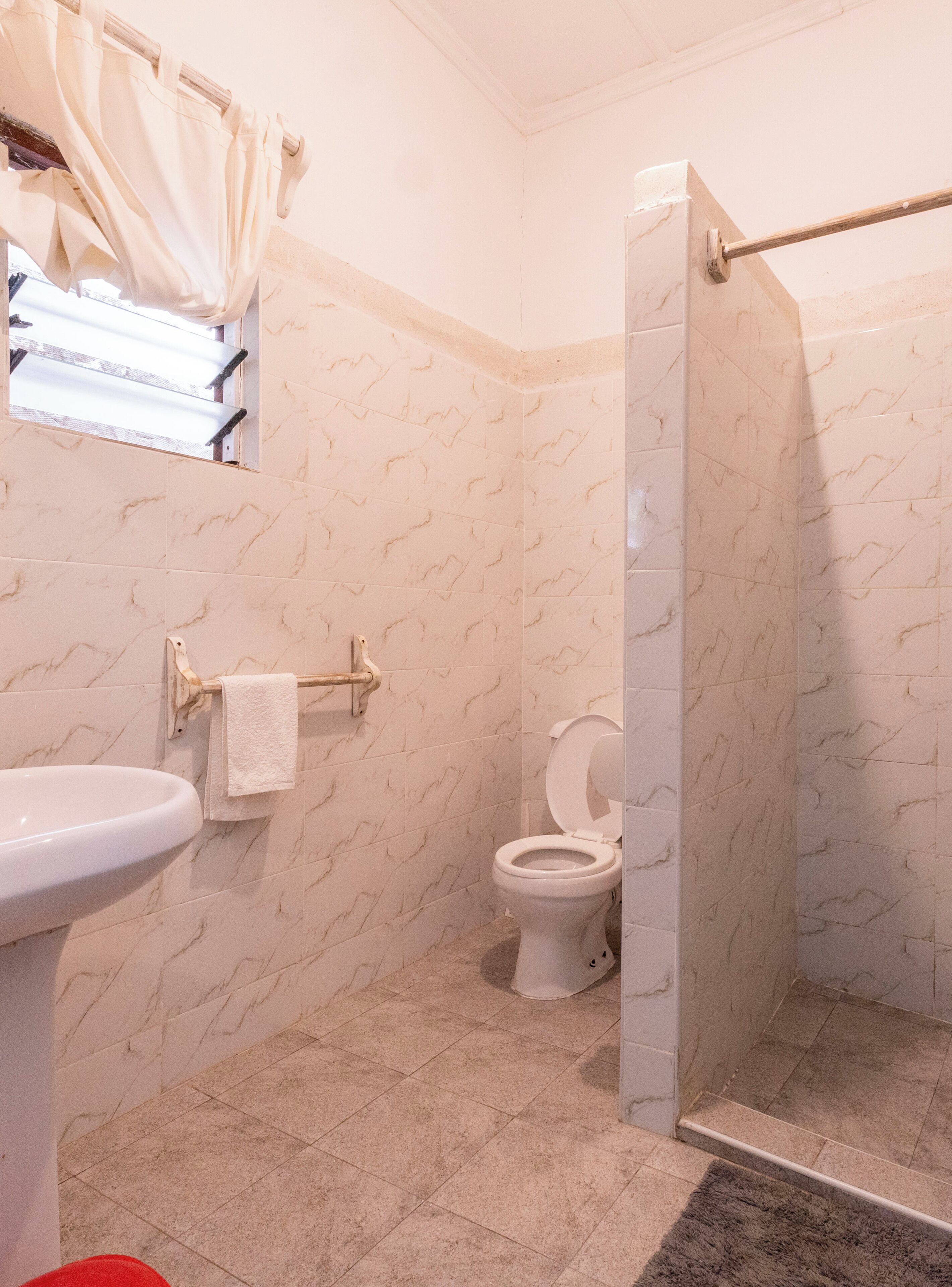 A bathroom with a toilet, sink, and shower area.