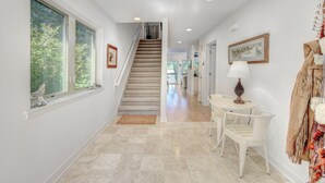 A hallway with a staircase, a dining area with a table and chairs, and a coat rack with a fur throw. -  Dells treetop lakeside lodging on famous Canyon Road. A top location! (Wisconsin Dells)