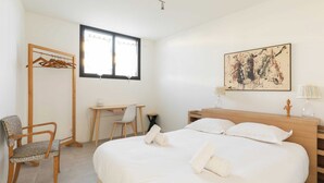 A hotel room with a bed, a desk, a chair, a wardrobe, and a window. - Dify Stoppa - Parilly (Venissieux)