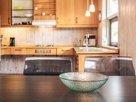 Una cocina moderna con armarios de madera, estufa y lavamanos.