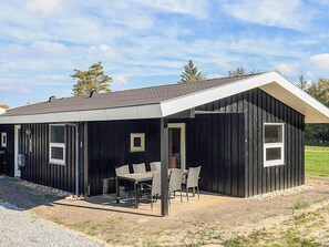 A black metal building with a covered patio area, a door, and a window. - 4 Person Holiday Home in Hals (Hals)