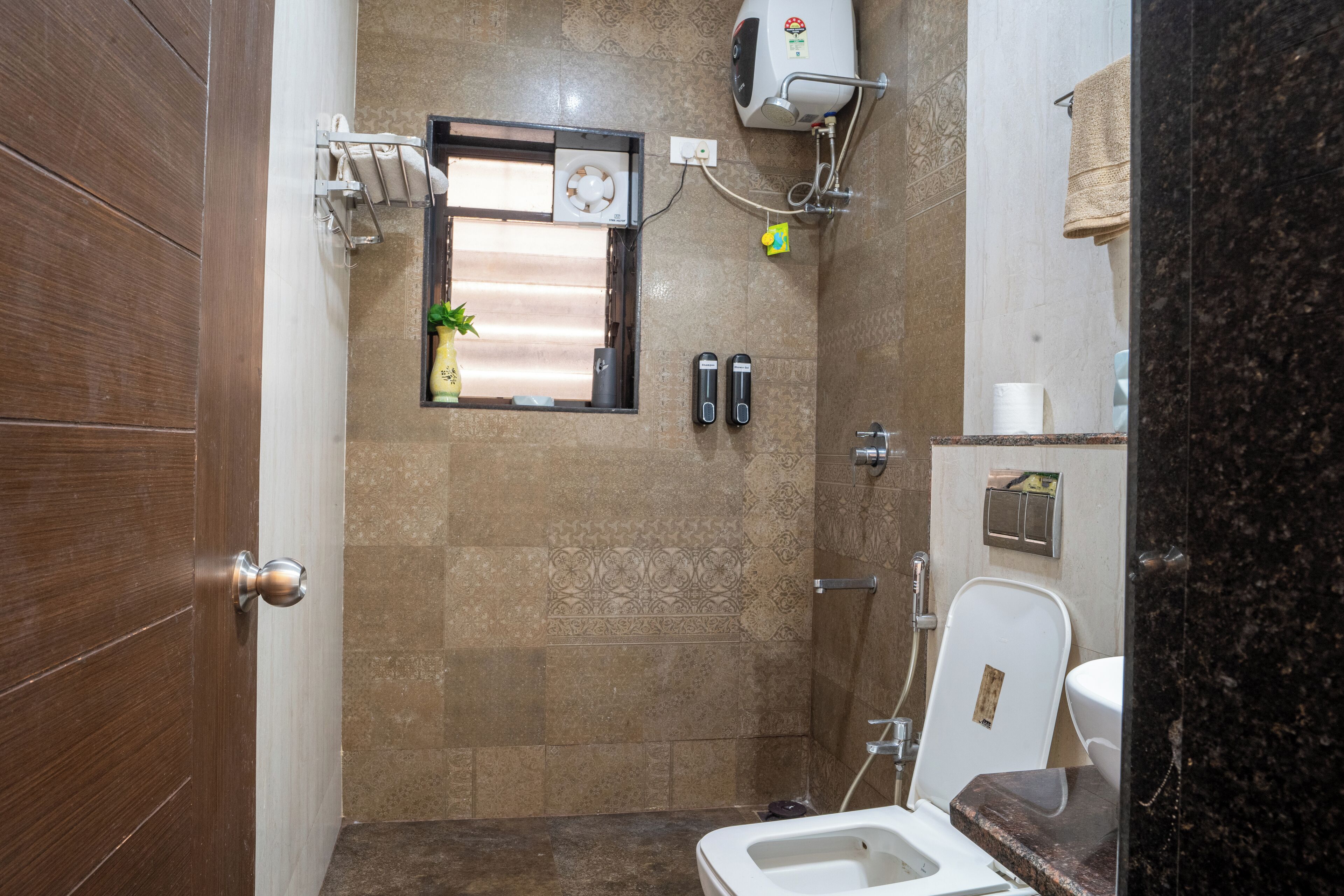 Un baño pequeño con inodoro, lavabo, toallero y ducha.