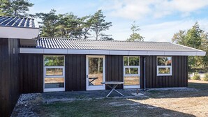 A modern building with a flat roof, large windows, and a covered outdoor area with a table. - 4 Person Holiday Home in Hals (Hals)