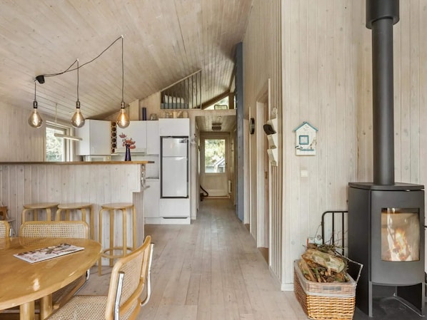 A spacious kitchen with wooden cabinets, a central island, and hanging pendant lights. - 8 Person Holiday Home in Rodby (Rodby)