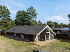 A single-story cabin with a porch, a small deck, and a solar panel array on the roof. - 8 Person Holiday Home in Rodby (Rodby)