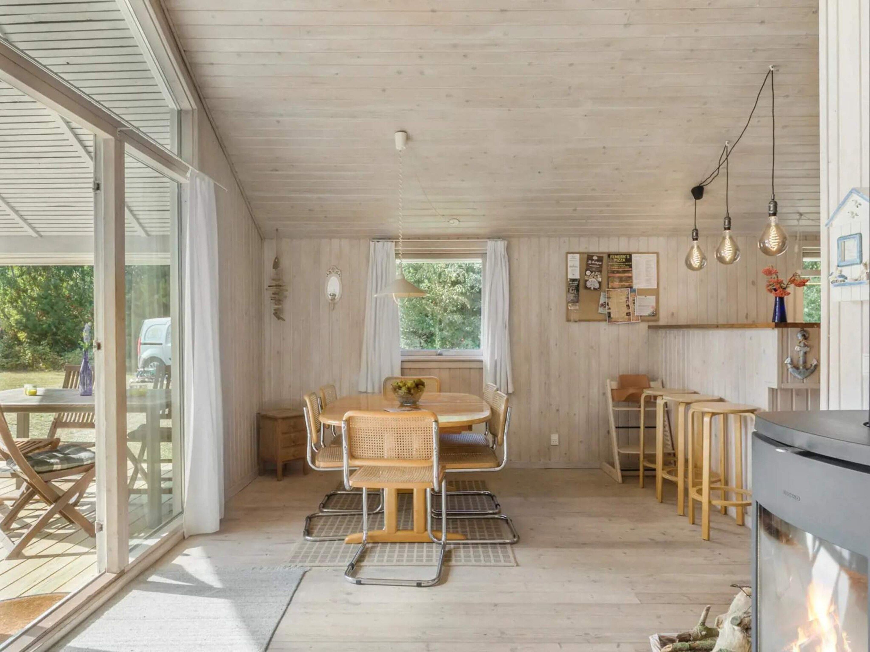 Una cocina moderna con estufa integrada, armarios de madera e iluminación colgante.