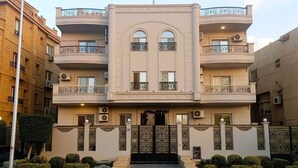 A multi-story building with balconies, air conditioning units, and a gated entrance.