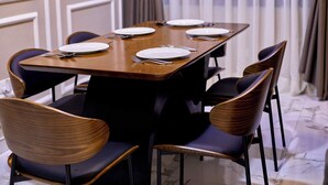 A dining table with six chairs, each with a dark cushion and a wooden frame. - 3-bedroom 3.5-ba house in a gated community in Accra with AC. Family-friendly (Kwabenya)
