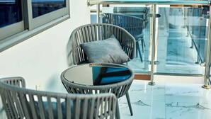 A modern indoor seating area with wicker chairs and a glass table, featuring a view through a glass railing. - 3-bedroom 3.5-ba house in a gated community in Accra with AC. Family-friendly (Kwabenya)