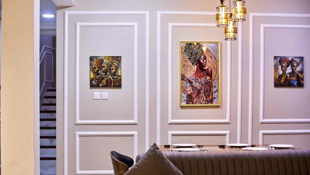 A room with a sofa, a chandelier, and framed artwork on the walls. - 3-bedroom 3.5-ba house in a gated community in Accra with AC. Family-friendly (Kwabenya)