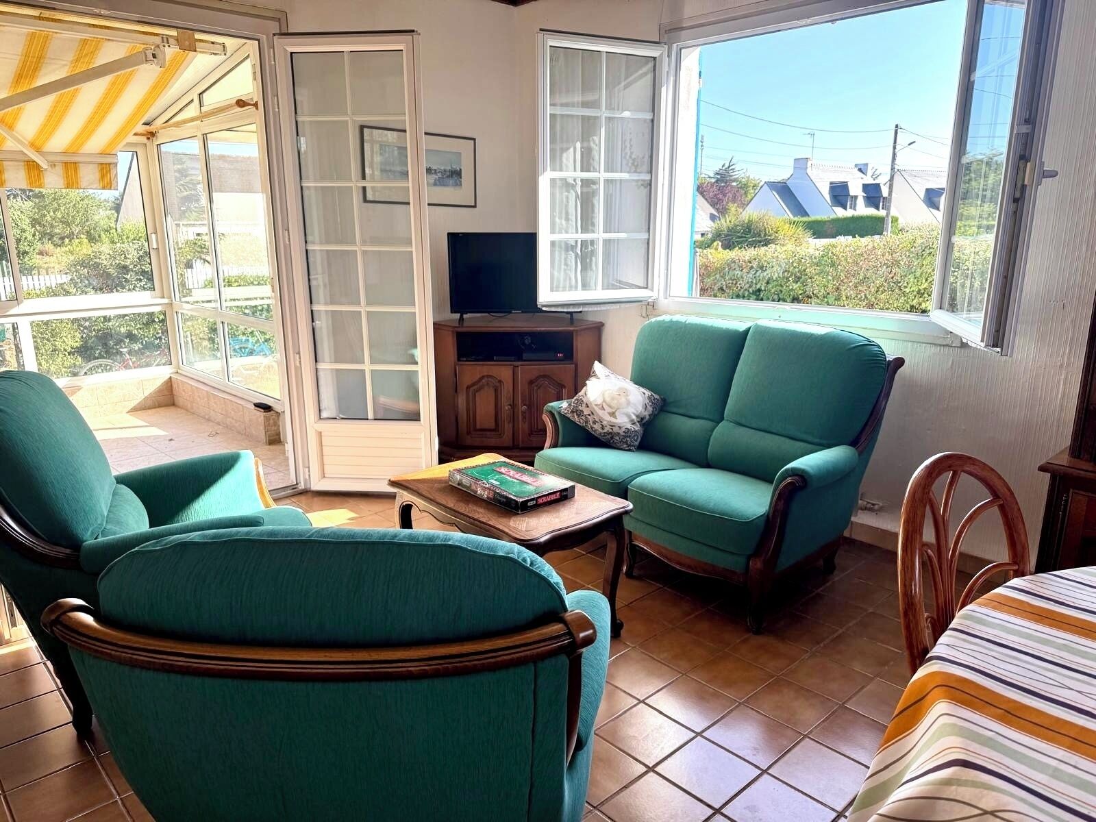 A cozy living room with a green sofa, a wooden coffee table, and a television.