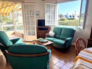 A cozy living room with a green sofa, a wooden coffee table, and a television.