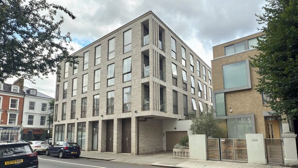 A multi-story building with a modern architectural design, featuring a mix of brick and glass facades.