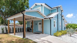 A two-story house with a covered patio, a front door, and a small porch area.