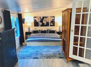 Une chambre à coucher avec un lit, une commode, un tapis et une porte.