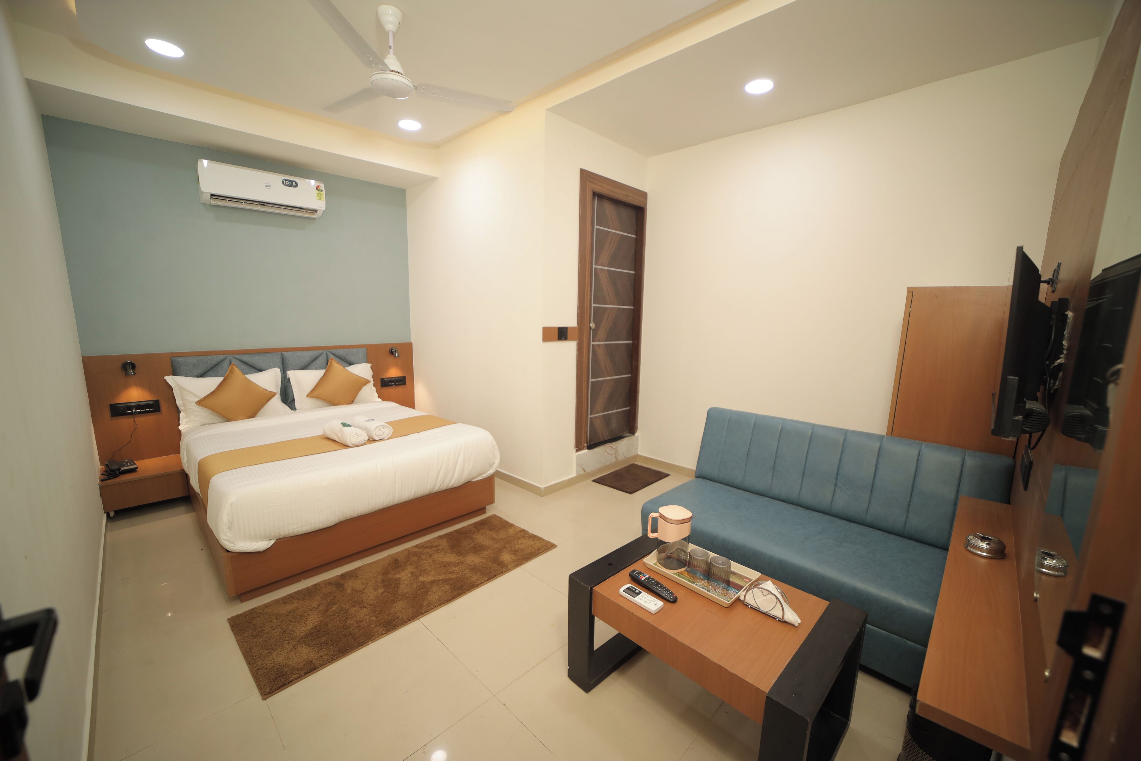 Une chambre d’hôtel moderne équipée d’un lit, d’un canapé, d’une table basse et d’un appareil de climatisation.