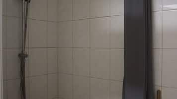 Een douche, handdoeken, toiletpapier