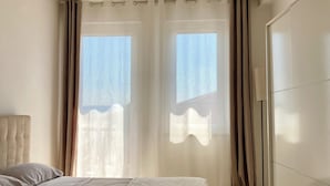 A bedroom with a large bed, a wardrobe, and a ceiling light fixture. - Jaris Apartment (Vicenza)