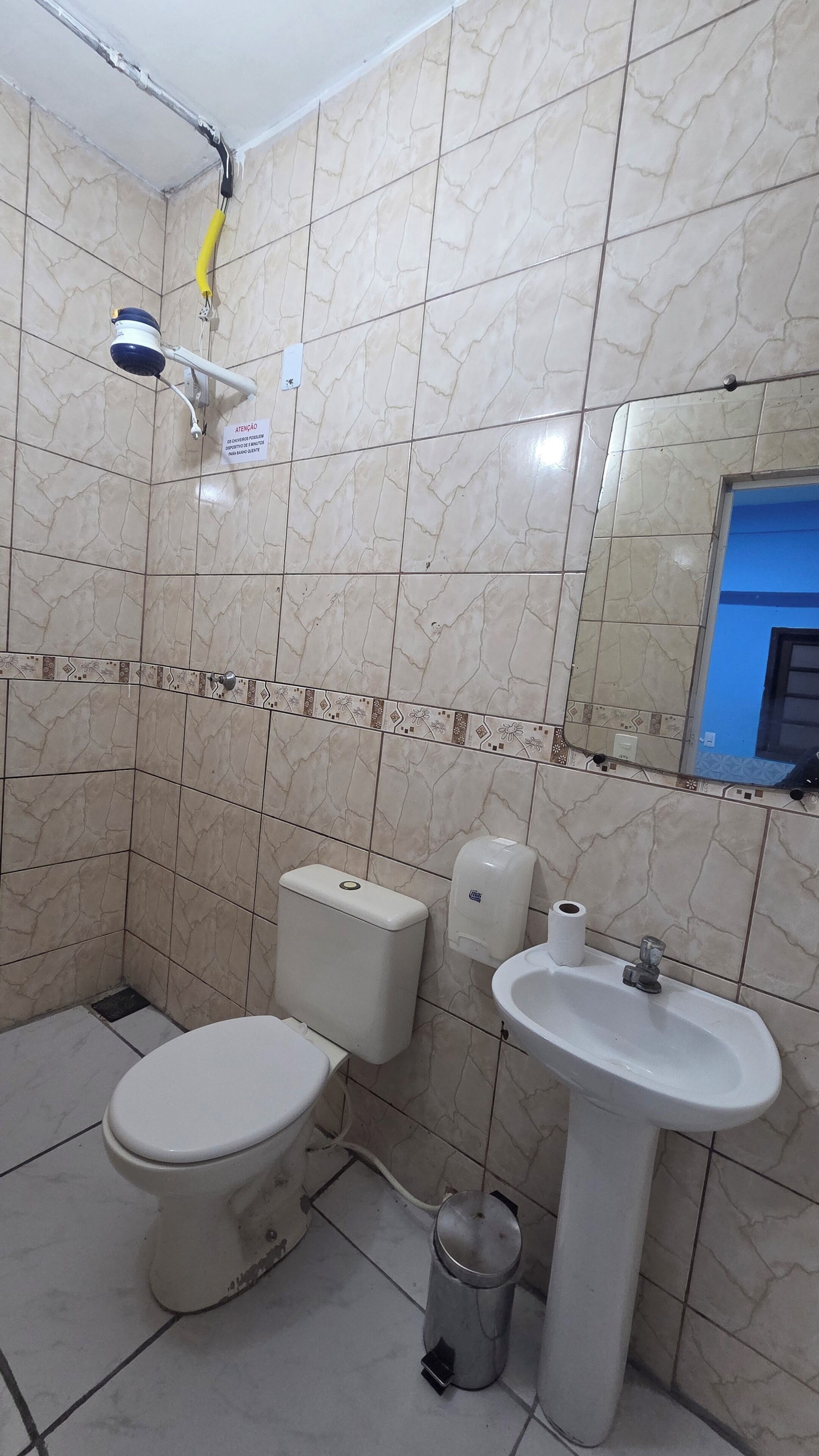A bathroom with a toilet, sink, and shower.