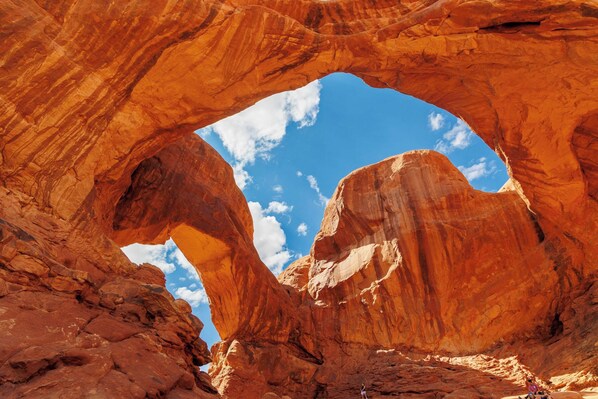 A natural rock arch formation with a clear sky visible through the opening.