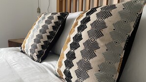 Een bed met twee kussens met een geometrisch patroon.