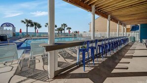 A covered pool area with lounge chairs and a pool number sign.