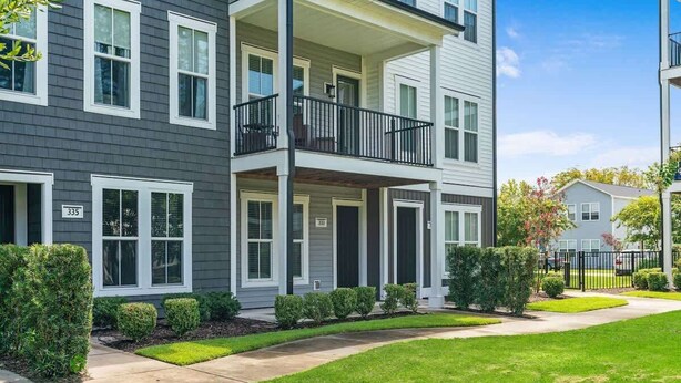 A multi-story apartment building with a balcony on the second floor. - One Tree Hill Townhouse - Downtown w/Garage! (Wilmington)
