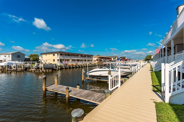 A waterfront hotel with a dock, boats, and a boardwalk.
