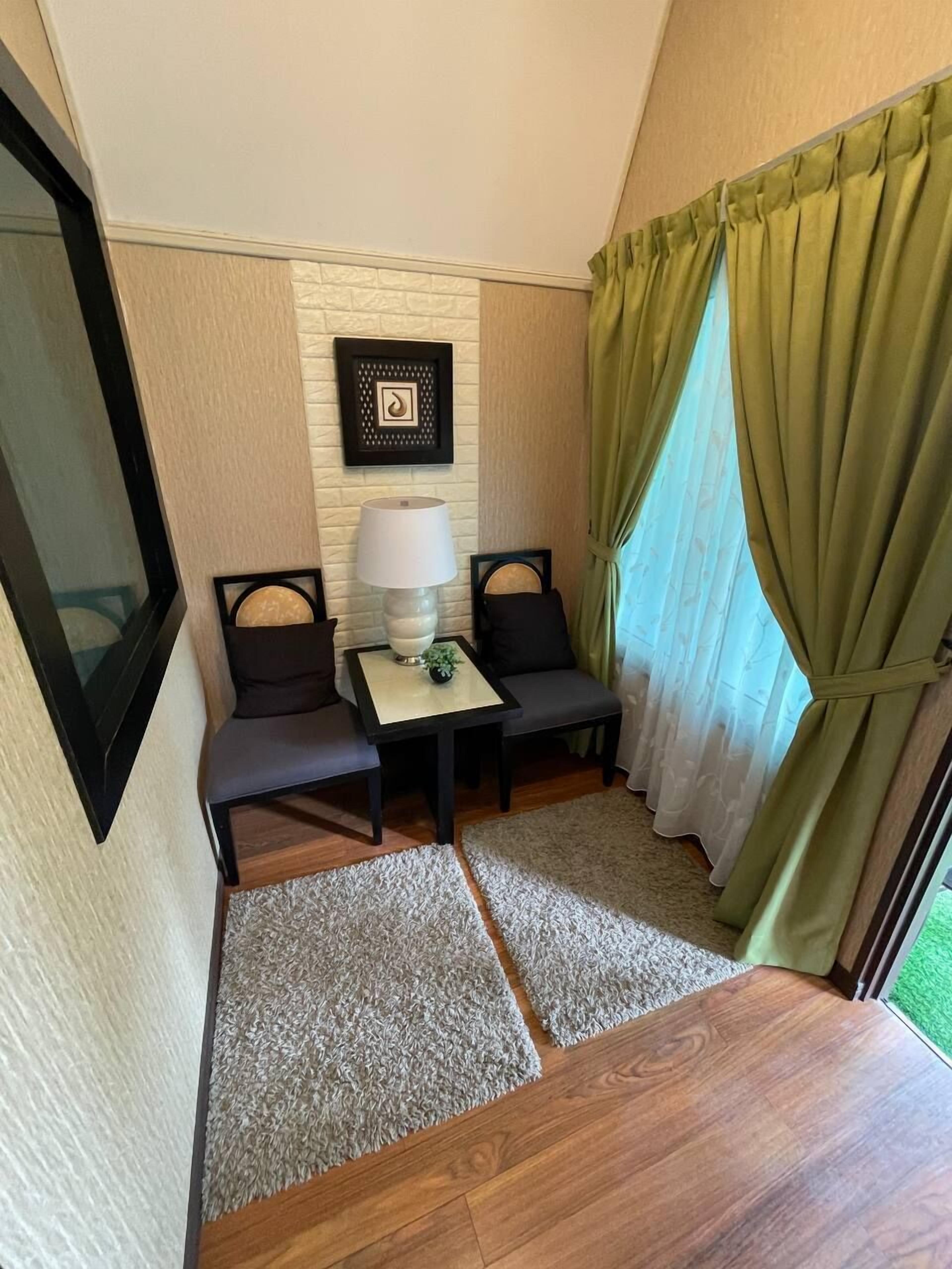 A compact room with a sofa, a small table with a lamp, and a framed picture on the wall.