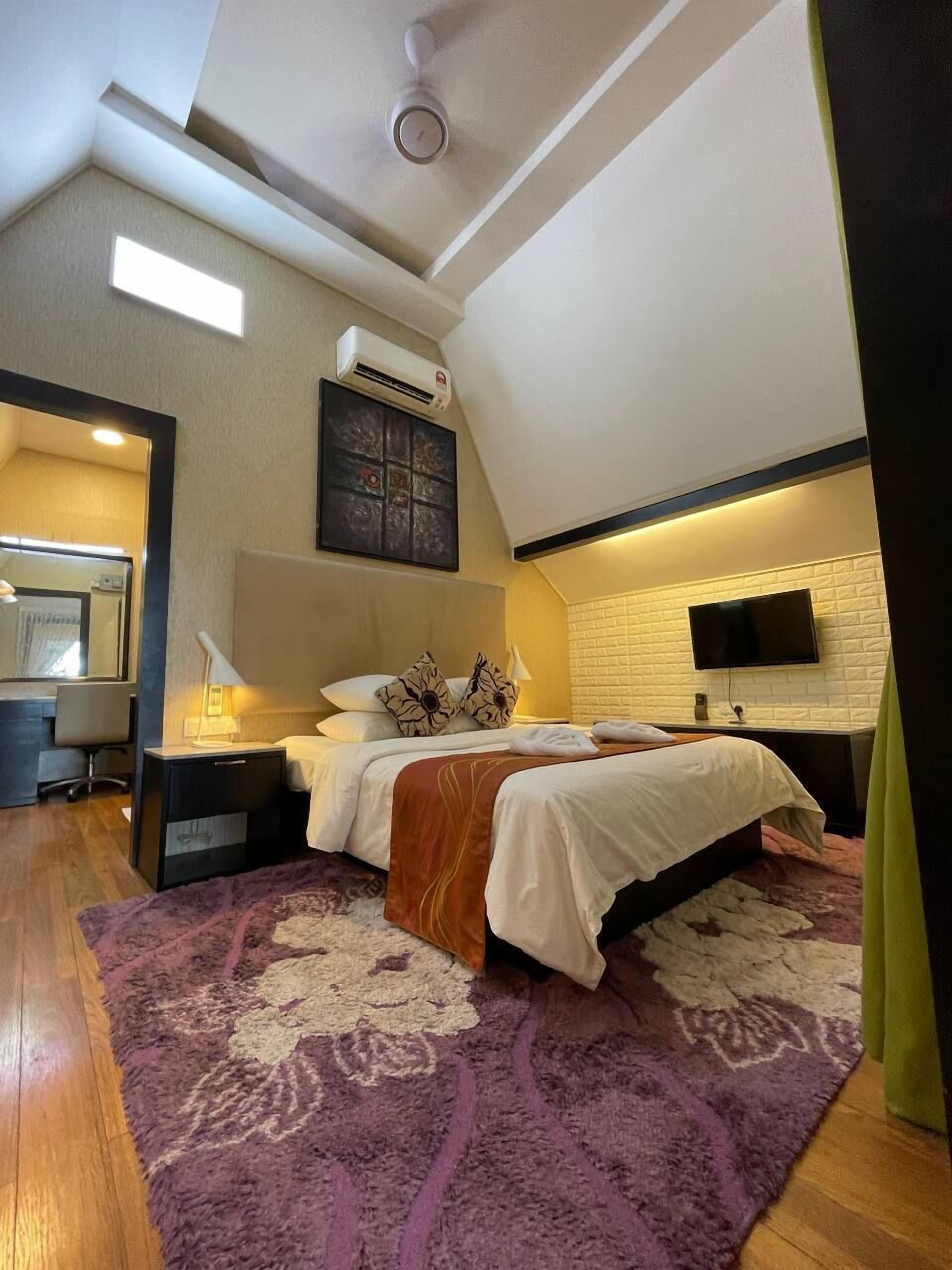 Een moderne slaapkamer met een groot bed, een flatscreen televisie en een plafondventilator.