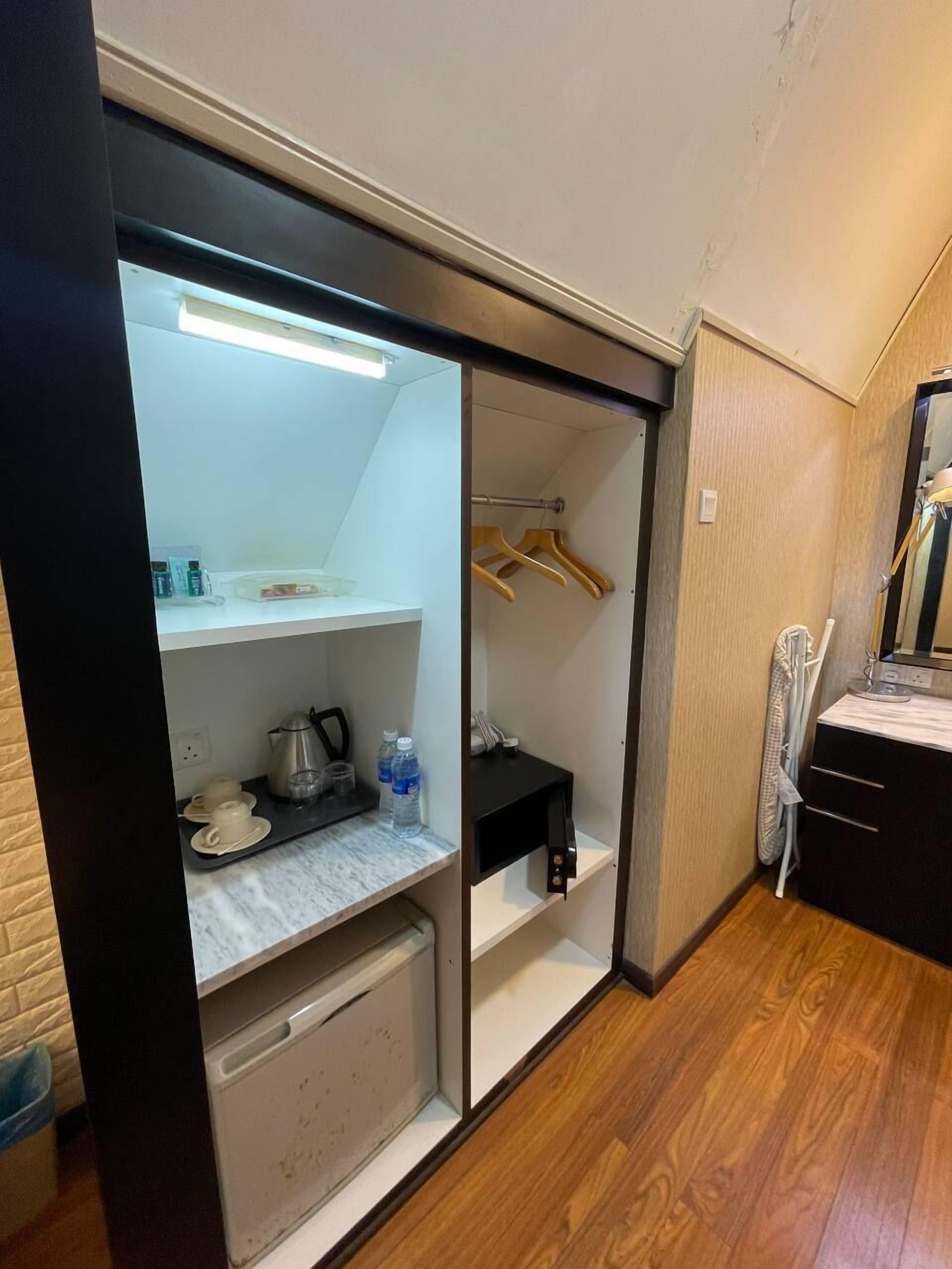 Une pièce compacte comprenant un coin cuisine, une petite salle de bain et un plancher en bois.