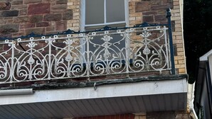 A building with a stone facade, a metal balcony railing, and a window. - Seaside Apartments (Ilfracombe)